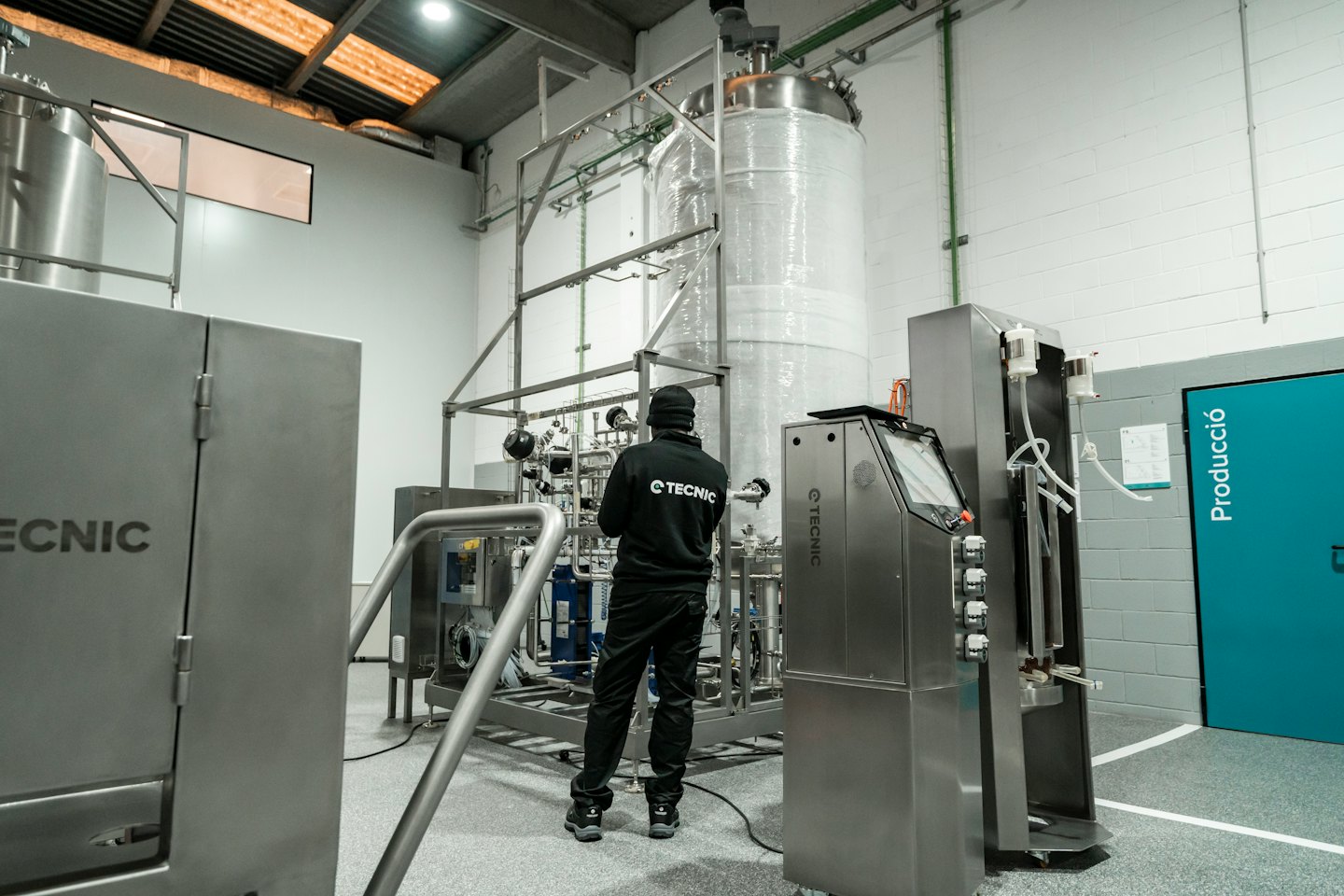 Home Technician inspecting complex stainless steel industrial machinery.