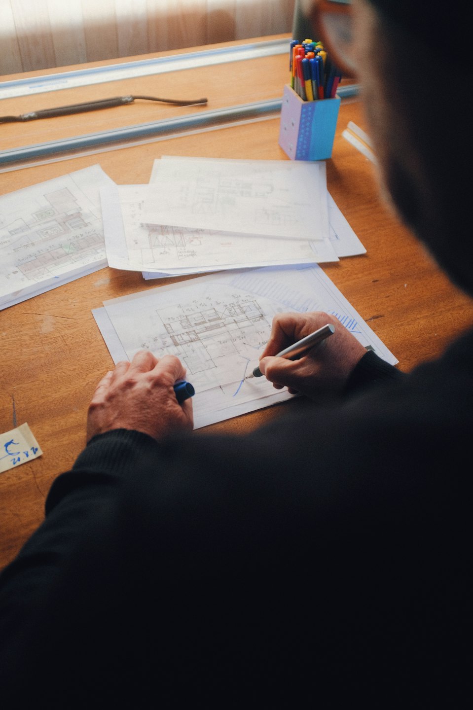 Services Person drawing architectural plans on a drafting table.